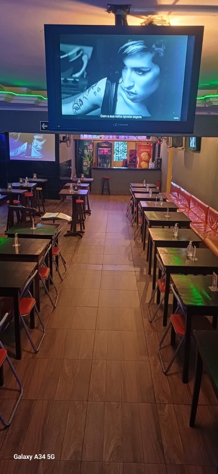 Telão de karaokê com as mesas do salão montadas